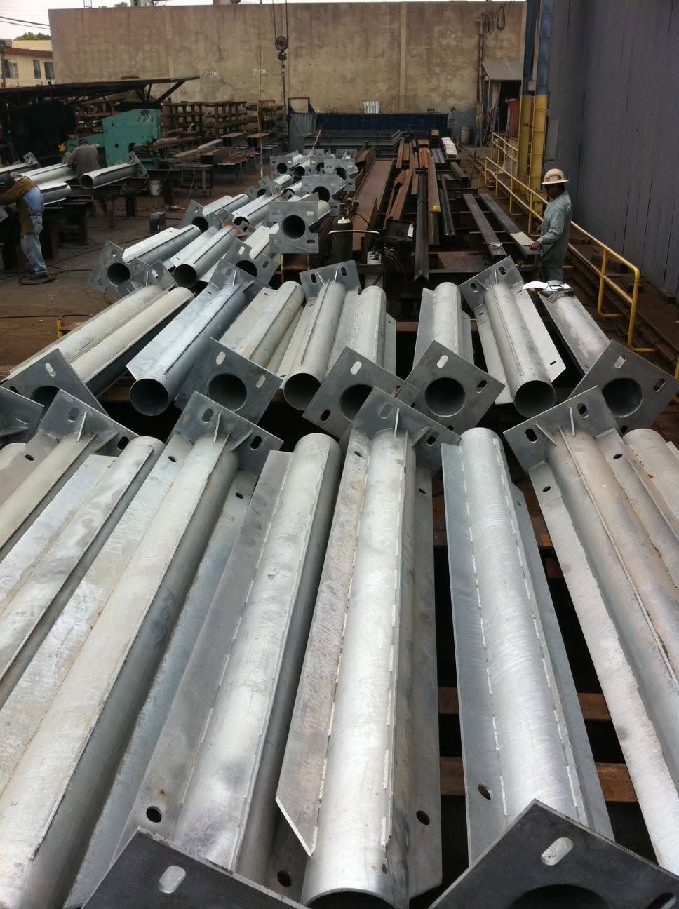Galvanized steel columns with base plates in the shop yard